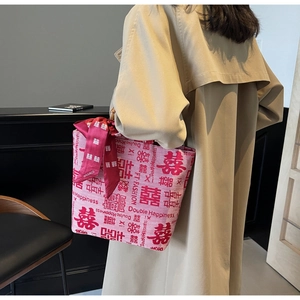 Detail of red bridal tote bag with Double Happiness embroidery and bamboo handle