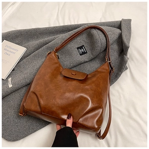 Close-up of vintage brown PU leather Hobo bag with stylish pleated details and flap