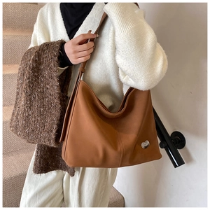 Detail view of large brown faux leather tote bag with silver metallic hardware and strap