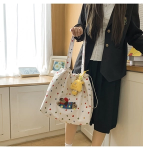 Detail of white canvas tote bag with colorful polka dots and teddy bear embroidery