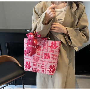 Detail of red bridal tote bag with bamboo handle and silk double happiness bow