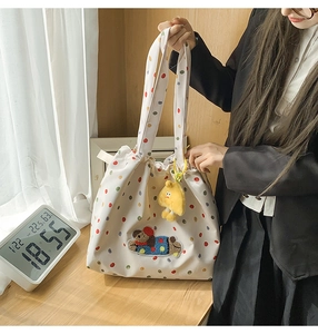 Close-up of white tote bag with colorful dots and plush puppy patch detail