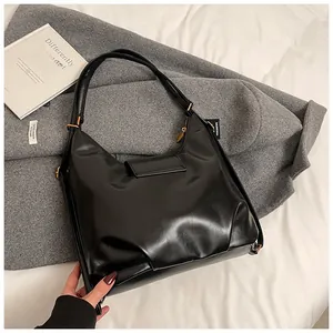 Detail of minimalist black leather hobo shoulder bag with zipper and adjustable strap