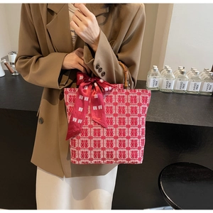 Detailed view of red bridal tote bag with bamboo handle and traditional Xi pattern