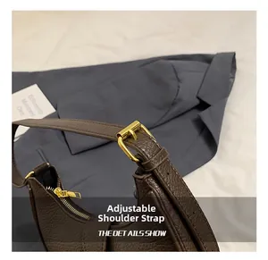 Detail of dark brown lychee leather strap with golden adjustable buckle and zipper