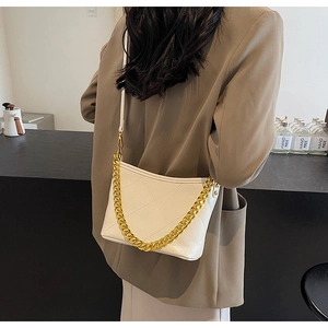 Elegante weiße gesteppte Beuteltasche mit goldener Kette in einer Lifestyle-Szene