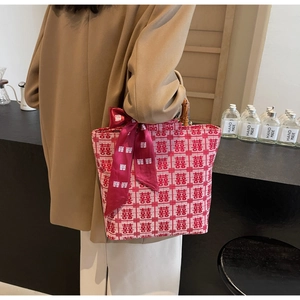 Detailed view of red wedding tote bag with bamboo handle and festive silk scarf detail
