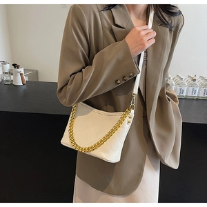 Detail der weißen gesteppten Beuteltasche mit Goldkette und strukturierter Kunstlederoptik