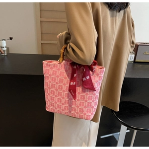 Detail of pink bridal tote bag with Xi character jacquard and vintage bamboo handle