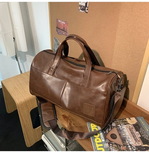 Detailed macro view of the vintage brown travel bag with embossed brand logo on the side