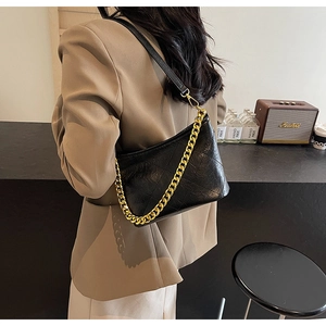 Detail der Retro-Stepp-Beuteltasche in Schwarz mit Goldkette und verstellbarem Gurt