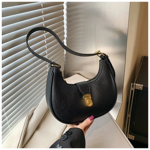 Detail of black pebbled leather hobo bag with a golden metal lock and zipper closure