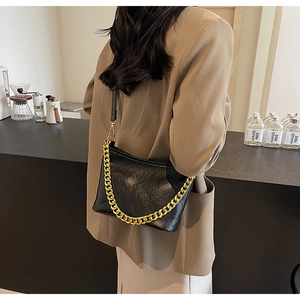 Detail der schwarzen gesteppten Beuteltasche mit goldener Kette und Leder-Schultergurt