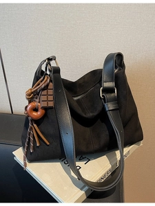 Minimalist black large capacity tote bag with suede texture and leather strap in a lifestyle setting