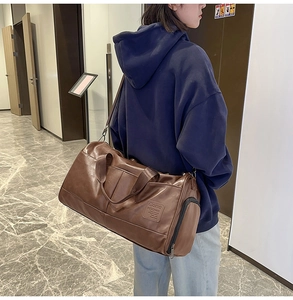 Deep brown large capacity travel bag in glossy PU leather with adjustable shoulder strap