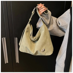 Detail of light green PU leather shoulder bag with matte finish and silver logo plate