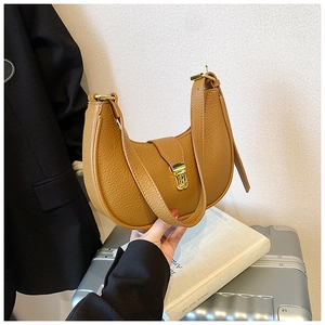 Detail of caramel brown moon bag with lychee texture leather and gold metal lock