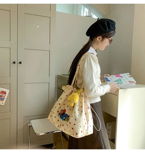 Detailed view of cream tote bag with colorful dots and cartoon bear embroidery