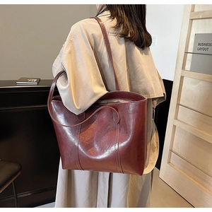 Vintage burgundy tote bag with contrast stitching styled with a beige trench coat
