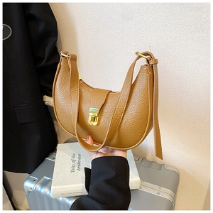 Detail of vintage brown textured leather hobo bag featuring a gold metal buckle closure