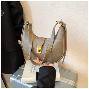 Detailed view of beige hobo bag showing pebbled leather texture and gold metal buckle