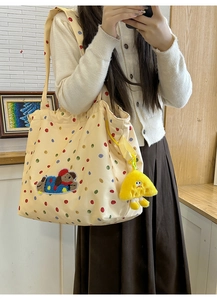 Close-up of beige canvas tote bag with colorful dots and cute dog embroidery detail