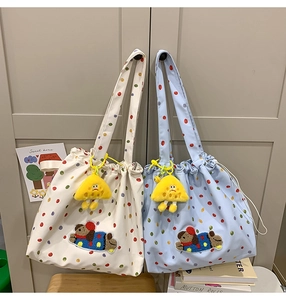 Detail of canvas tote bags featuring cute dog patches and yellow plush charms