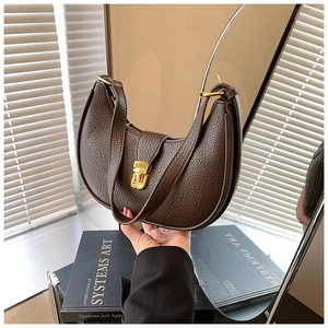 Detailed close-up of dark brown textured leather hobo bag with a gold metal push-lock clasp