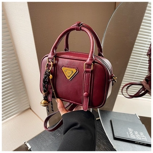 Nahaufnahme der dunkelroten Vintage-Ledertasche mit Goldlogo und Spiegelreflexionsdetail