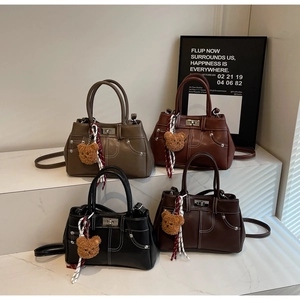 Detail view of four vintage leather handbags in khaki, wine red, black, and dark brown colors