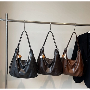 Dettaglio delle eleganti borse tote in pelle nei colori nero, marrone scuro e marrone
