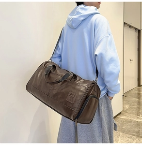 Close-up of vintage dark brown faux leather travel bag featuring side zip and top handles