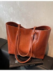Brown leather tote bag with white contrast stitching and large capacity for women