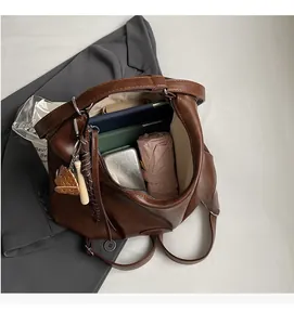 Vista macro dell'ampio scomparto interno della borsa tote in pelle marrone a pieghe