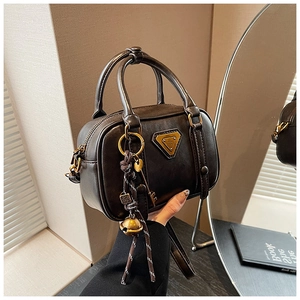 Details der dunkelbraunen Vintage-Boston-Tasche mit goldener Plakette und Anhänger