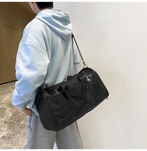 Black PU leather travel bag on model showing large capacity and adjustable strap
