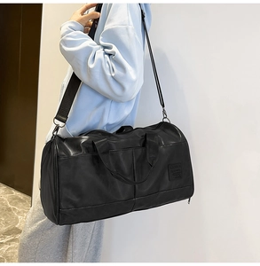 Detailed side view of a black large-capacity travel duffel bag with wide nylon shoulder strap
