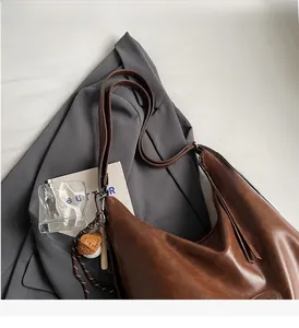 Borsa hobo marrone grande con pieghe, ciondolo baseball e ampia tracolla