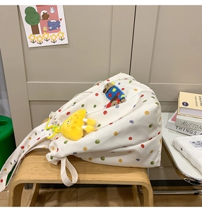 Detail of white canvas tote bag with colorful polka dots and cute teddy bear applique