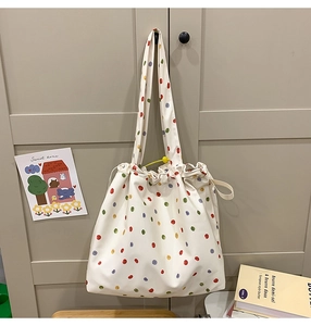Close-up of canvas tote bag with colorful polka dots and drawstring closure detail
