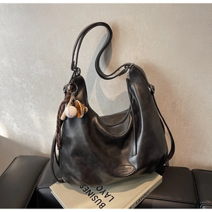 Dettaglio della borsa hobo in pelle nera opaca con un portachiavi a tema baseball