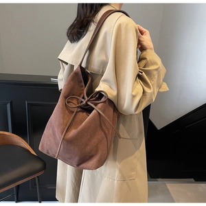 Detail of brown vintage tote bag with soft matte finish and stylish ribbon closure
