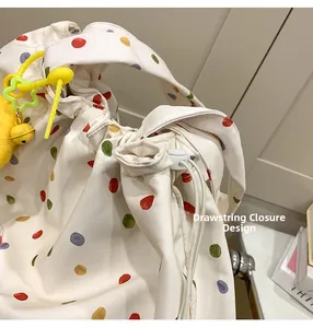 Close-up of the drawstring closure and toggle adjuster on a colorful polka dot tote bag