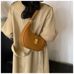 Detail of vintage brown crescent bag with lychee texture and gold metal clasp