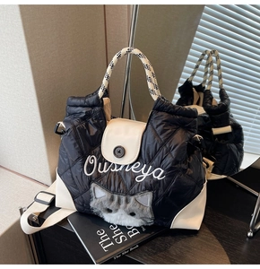 Schwarze gesteppte Shopper-Tasche mit Plüschkatzengesicht und kariertem Griff im Spiegel