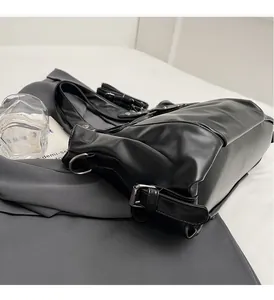Gros plan de la boucle argentée polie et du cuir noir souple de ce grand sac cabas