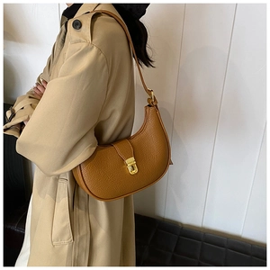 Brown half-moon hobo bag with pebble leather texture and gold buckle on a model