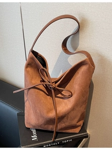 Vintage brown suede tote bag with leather bow accent and spacious hobo style design