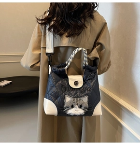 Gesteppte Tragetasche mit Plüschkatzen-Deko an Model im Trenchcoat