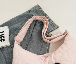 Detail view of adjustable wide shoulder strap on pink heart quilted nylon tote bag